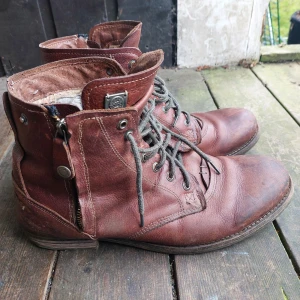 Bruna skinnkängor med snörning och dragkedja - Säljer ett par bruna kängor i skinn med snörning. De har en varm fodring inuti, perfekt för kyligare dagar. Kängorna har en robust design. Svensk hållbar design från Göteborgsmärket Sneaky Steve!