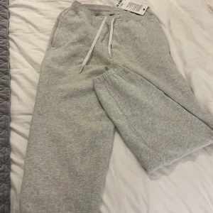 Lululemon Grå mjukisbyxor  - Säljer ett par grå mjukisbyxor från lululemon i storlek S. Byxorna har en bekväm passform med snörning i midjan och elastiska muddar vid bensluten. Perfekta för en avslappnad stil eller till gymmet! Oanvända men säljer pga fel storlek