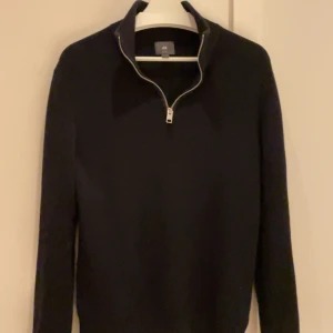 Svart quarter zip tröja - Säljer en stilren svart långärmad quarterzip tröja från H&M. Perfekt under jacka nu under de kallare tiderna. Tröjan har en klassisk design som passar till många tillfällen. Hör av er vid frågor!