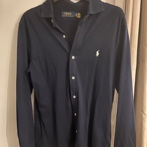 Ralph Lauren skjorta  - Snygg mörkblå skjorta från Ralph Lauren. Köpte den ungefär i somras på nk. Skick 9/10, ny pris ungefär 1900 mitt pris 650. Hör av dig ifall du har några funderingar. Kan gå ner i pris vid snabb affär😊