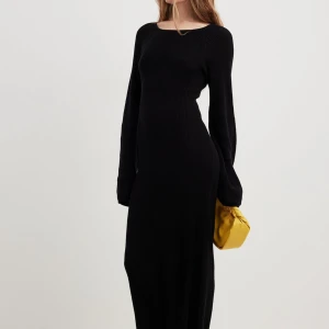 Svart långklänning med öppen rygg - Elegant svart långklänning med ribbad struktur och en fantastisk öppen rygg med snörning. Klänningen har långa ärmar och en figurnära. Så snygg till våren eller sommaren! Använd endast ett fåtal gånger