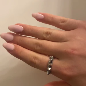 Silver edblad ring - Snygg silvrig ring med nitar som ger en edgy look. Perfekt för att addera lite attityd till din stil. Ringen har en slät insida för bekväm passform.