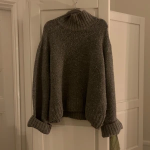 Grå stickad polotröja - Mysig grå stickad polotröja med ribbad krage och muddar. .