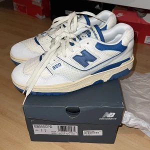 New Balance 550 - Snygga New Balance 550 sneakers i vitt och blått med klassisk snörning. De är helt nya, oanvända. Dem är storlek 42,5. Priset kan diskuteras.