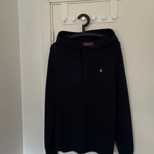 Mörkblå hoodie från Morris - Säljer en stilren mörkblå hoodie från Morris i storlek M. Den är använd 3 gånger. Den är perfekt nu till våren .