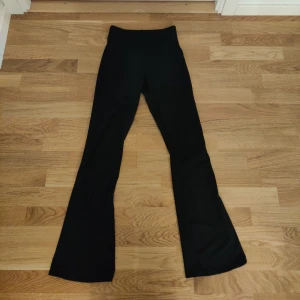 Svarta ribbade leggings  - Snygga svarta leggings med ribbad textur och bootcut-stil. De är högmidjade och är i en Petite längd.