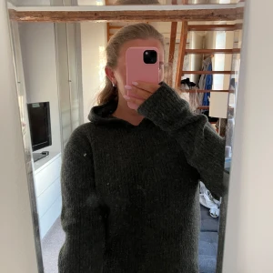 Mörkgrön stickad hoodie från Weekday - Säljer en mysig mörkgrön stickad hoodie från Weekday. Perfekt för kyliga dagar med sin varma och bekväma design. Tröjan har en klassisk huva och långa ärmar. Priset kan ändras 