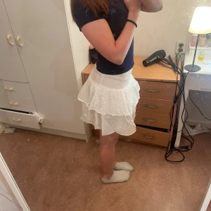 Vit prickig kjol med volang - Söt vit kortkjol med prickigt mönster. Kjolen har en luftig och bekväm passform. Använd c 3 ggr🩷