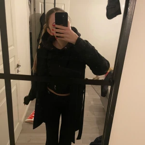 Svart kappa från Pieces - Säljer en stilren svart kappa från Pieces i storlek M. Perfekt för höst och vinter med sin klassiska design och långa ärmar. Kappan har en elegant krage och är i mycket bra skick. Passar både till vardags och festliga tillfällen.