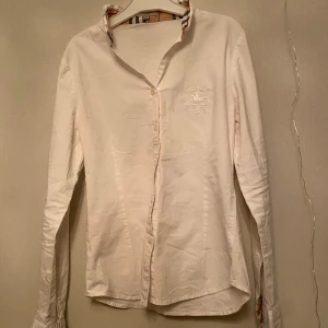 Burberry skjorta - Säljer en stilren vit skjorta från Burberry i mycket bra skick. Storleken är M i barn storlek som är storlek 152 ungefär. 