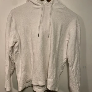 Vit hoodie från Samsøe Samsøe - Säljer en supermjuk och stilren vit hoodie från Samsøe Samsøe. Perfekt för kyliga dagar med sin mysiga luva och långa ärmar. Den är i bra skick och passar till alla tillfällen. Skön och enkel att matcha med andra plagg. Perfekt för både vardag och avslappnade stunder.