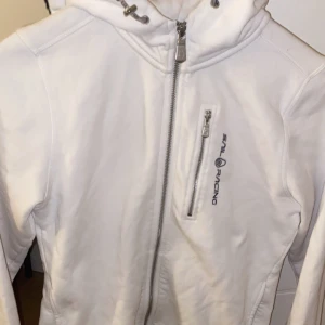 Vit jacka från Sail Racing - Säljer en snygg vit jacka från Sail Racing i mycket bra skick. Den har en dragkedja framtill och en praktisk bröstficka med dragkedja. Perfekt för vår och höst! 🏄‍♂️