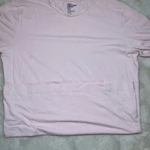 Ljusrosa t-shirt från Fruit of the Loom - Säljer en enkel och stilren ljusrosa t-shirt från Fruit of the Loom. Den är kortärmad och gjord i mjukt bomullsmaterial, perfekt för vardagsbruk. Passar bra till både jeans och shorts. Perfekt basplagg för sommaren! 🌸