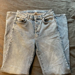 Ljusblå jeans - Ljusblå jeans från BikBok, bra skick. Slitning längst ner baktill på ena byxbenet (se bild). Storlek 36/38. Innerbenslängd: 80cm. Midjemått: 32cm.