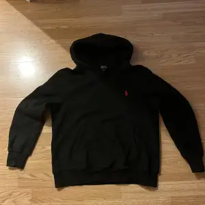 Säljer en klassisk svart hoodie från Ralph Lauren i storlek M. Den har en röd broderad logga på bröstet och en bekväm passform. Perfekt för höst och vinter, med en mysig huva och ficka framtill. Skön och stilren för alla tillfällen! Hoodien är i storlek M men passar bättre för S enligt mig!