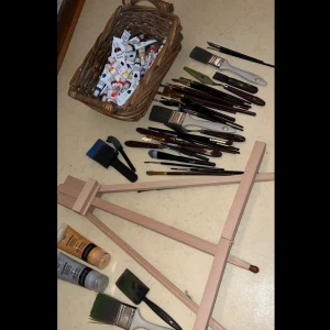 Målarset med staffli och penslar - Säljer ett komplett målarset med ett trästaffli, en korg full med färgtuber och en stor samling penslar i olika storlekar och former. Perfekt för både nybörjare och erfarna konstnärer. Staffliet är stabilt och lätt att justera. Penslarna har både trä- och plastskaft, och färgtuberna är i olika nyanser. Allt du behöver för att komma igång med ditt nästa konstprojekt! 🎨