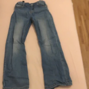 Blå jeans från Pollen O. Pyret - Säljer ett par snygga blå jeans från Pollen O. Pyret. De har en klassisk femficksdesign och en bekväm passform. Perfekta för vardagsbruk och kan enkelt matchas med olika toppar. Jeansens slitna look ger dem en cool och avslappnad stil. Ålder 7-8 år 