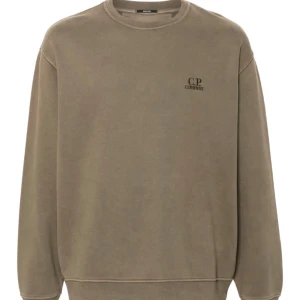Ljus grön sweatshirt från C.P. Company - Säljer en stilren grön sweatshirt från C.P. Company i mycket bra skick. Den har en normal passform och är perfekt för både höst och vår. Tröjan har långa ärmar och en liten logga på bröstet. Superbekväm och lätt att matcha med olika outfits!