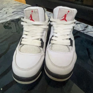 Nike Air Jordans i vitt och grått - Säljer ett par snygga Nike Air Jordans i vitt med grå och svarta detaljer. Skorna har den klassiska Jumpman-loggan i rött på plösen och Nike Air-loggan på hälen. Perfekta för både vardag och fest! De är i mycket bra skick och redo för nya äventyr. Dom e lite smutsiga kan tvätta dom, Priset kan diskuteras