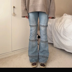 Blå bootcut jeans med detaljer - Säljer ett par snygga blå bootcut jeans med unika detaljer. De har en cool design med ribbade partier runt benen som ger en extra touch. Perfekta för både vardag och fest! Passar bra till en oversized tröja och sneakers för en avslappnad look.