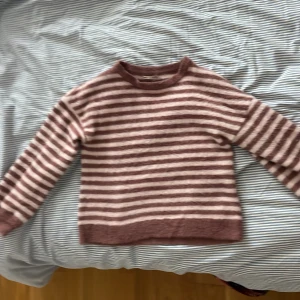 Randig tröja från ONLY - Mysig och fluffig tröja från ONLY i rosa och vit randigt mönster. Perfekt för kyliga dagar med sin långärmade design och mjuka material. Passar både till vardags och mysiga hemmakvällar. 🧡