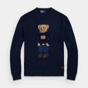 Mörkblå tröja med nallemotiv Ralph lauren  - Säljer en superfin mörkblå tröja med ett gulligt nallemotiv på framsidan. Perfekt för att hålla sig varm och stilren under kyliga dagar. Tröjan har långa ärmar och är i Nytt skick. Passar perfekt till både vardag och lite mer avslappnade tillfällen. 🐻💙 Den är helt ny bara att ja har bytt stil kostar egentligen 5665 fast ja säljer den billigare då ja aldrig använt den o vill att nån ska köpa den.