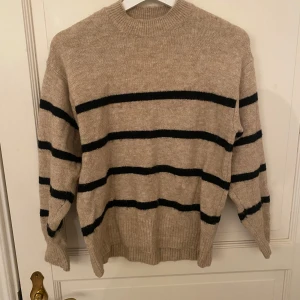 Beige randig tröja H&M - Säljer en supermysig beige-och-svart randig tröja från H&M i storlek S. Varan har används ett par gånger och har några få noppror på ärmarna💕