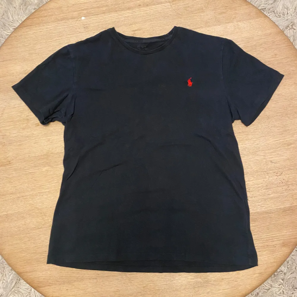 Säljer en svart t-shirt från Polo Ralph Lauren i storlek M. 9,5/10 skick som ny. Kvitto och box ingår ej vilket är anledningen till att jag säljer den billigt. Priset ska inte sänkas mycket men går att diskuteras vid en snabb affär. Kom gärna med prisförslag och frågor!. T-shirts.