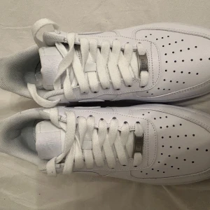 Vita Nike Air Force 1 sneakers - Säljer ett par klassiska vita Nike Air Force 1 sneakers i nytt skick. Använt dem för o testa hemma bara storlek 43. 