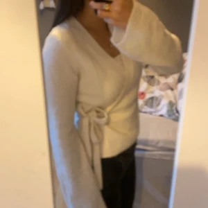 Vit omlottopp - Säljer en superfin vit omlottopp med knytband i sidan.  Den är inte använd alls, nyköpt men för stor. Storlek M.