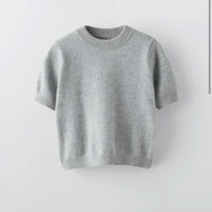 OANVÄND Grå stickad tröja från Zara - Oanvänd Zara tröja köpte den för 599 Mysig grå stickad tröja från Zara i bra skick. Perfekt för kyliga dagar med sin kortärmade design och ribbade detaljer vid ärmslut och nederkant. Enkel och stilren, passar till det mesta i garderoben.