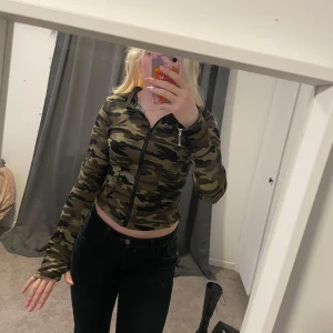 Camo zipup - Säljer en snygg camouflage mönstrad jacka med dragkedja framtill. Den är croppad och har en tight passform som sitter perfekt. Jackan är långärmad och passar perfekt för en cool och avslappnad stil. Perfekt för höst och vår! Använd en gång
