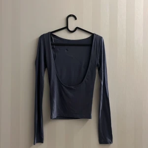 Gina Tricot Topp - Soft touch – second skin comfort. Långärmad topp i mjuk viskos med djup rygg. Toppen är grå och har figurnära passform.