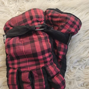 Röd-svart rutiga vinterhandskar - Säljer ett par snygga vinterhandskar med röd-svart rutigt mönster och svart handflata. De är fodrade med Thinsulate för extra värme. Perfekta för kalla dagar! 🧤