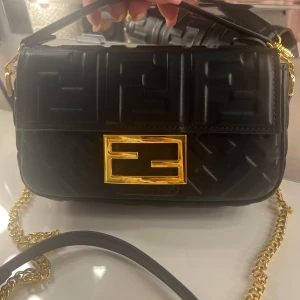 Fendi baguette bag mini - Suuuper snygg liten svart väska med guld detaljer. Både långa och korta bandet medföljer. Helt oanvänd, nyskick! 