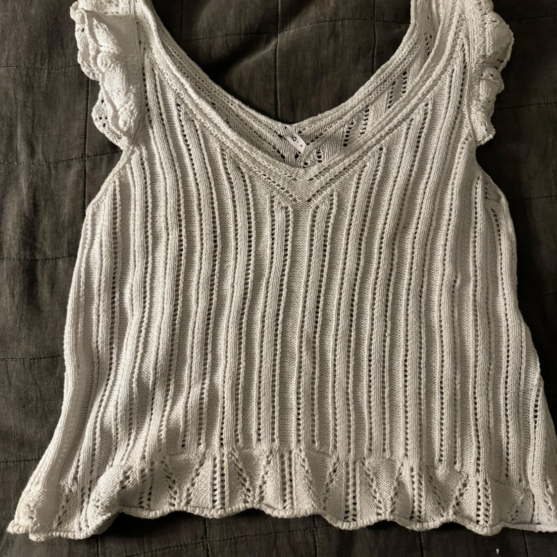 Vit stickad topp med volangdetaljer
