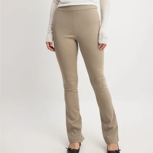 Beige byxor med slits - Snygga beige byxor i tight passform med hög midja. De har en stilren design med slitsar vid bensluten som ger en trendig touch. Perfekta för både vardag och fest! 🕺(helt nya med prislapp)