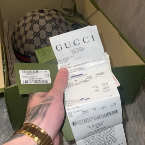 Gucci keps med monogram - Säljer en snygg Gucci keps i XS med det klassiska monogrammönstret. Kepsen är i bomull och har en justerbar rem baktill. Den är i nytt skick och kommer med originalförpackning och kvitto. Perfekt för att ge din outfit en lyxig touch!