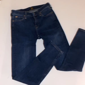 Mörkblå jeans från Lee - Säljer ett par mörkblåa 3/4 jeans från Scarlet i storlek W27 L33. De är tillverkade i en bomullsblandning med polyester och elastan för extra stretch och komfort. Perfekta för både vardag och fest! 🖤(Inte full längd alltså:)