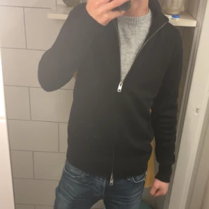 Full zip tröja - Säljer en svart långärmad full zip tröja Perfekt för höst och vår, den är både stilren och bekväm. Passar bra till jeans för en avslappnad look. Hör av dig vid intresse!