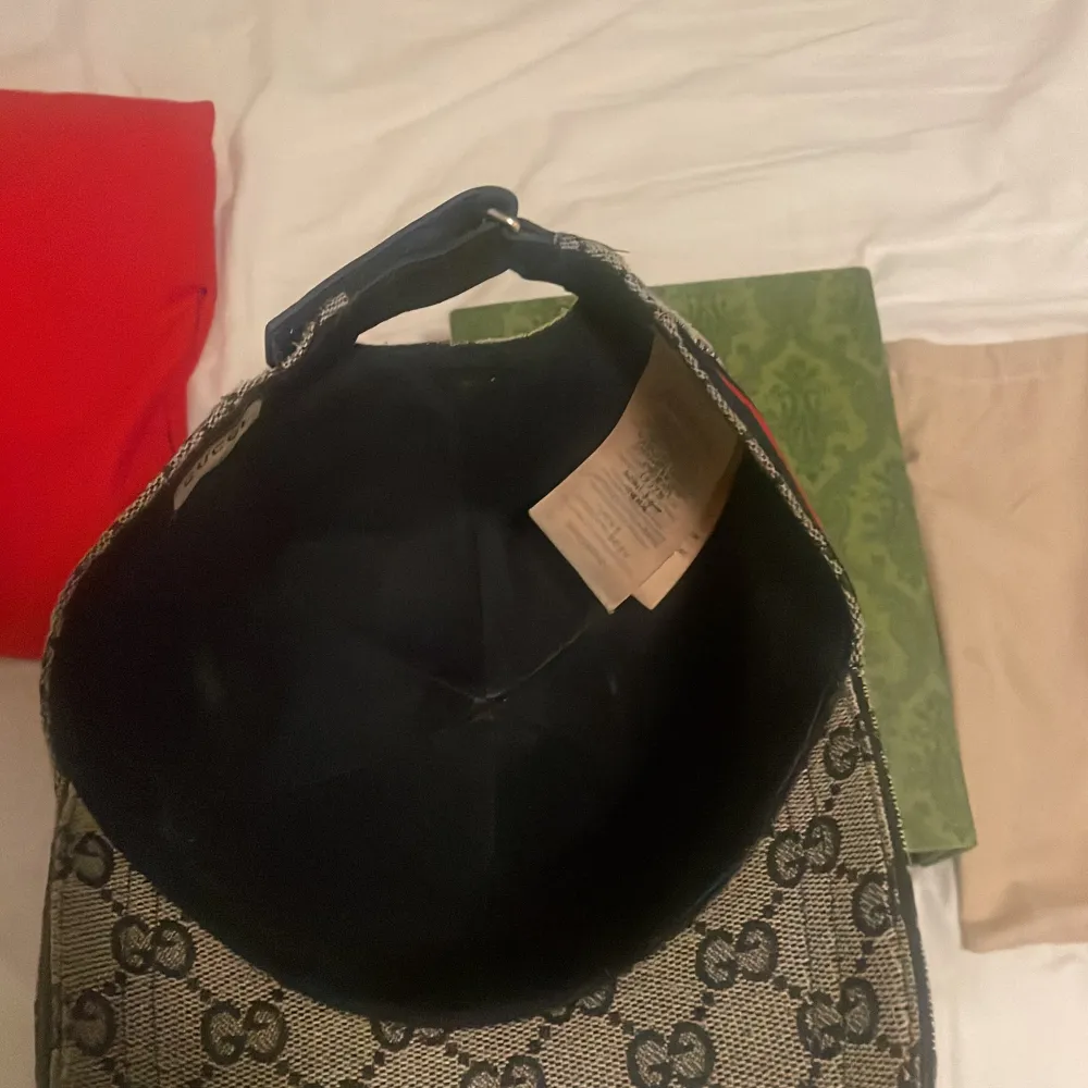 Säljer en snygg Gucci keps i storlek M, 57 cm. Den har det klassiska Gucci-monogrammet i grått och svart med röda och gröna detaljer på sidorna. Perfekt för att ge din outfit en lyxig touch. Kepsen kommer med originalförpackning och dustbag.ÄKTA. Accessoarer.