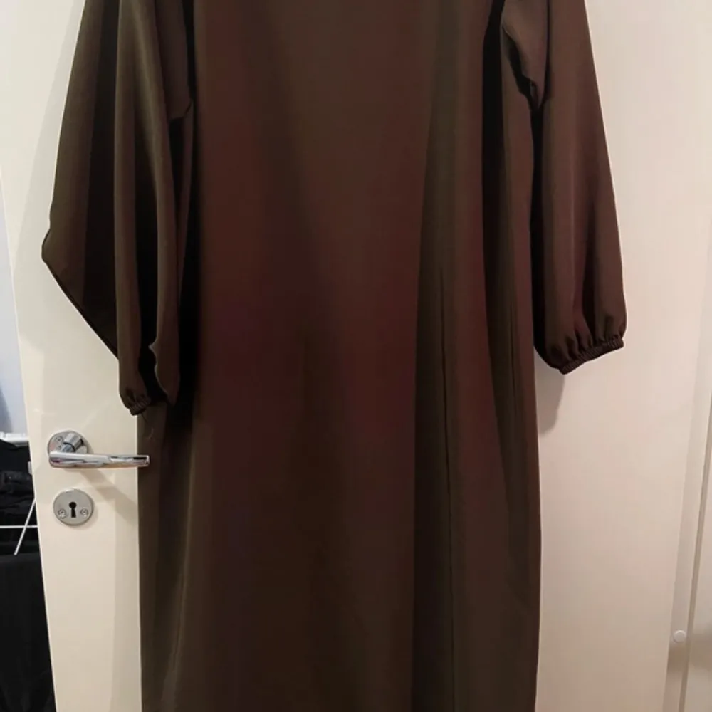 Detta är en enkel brun klänning/abaya den är i storlek S och är lite oversized så den passar även om man har M storlek på bilden har jag tagit med blixt så att man ser hur det ser ut på nära håll. . Klänningar.