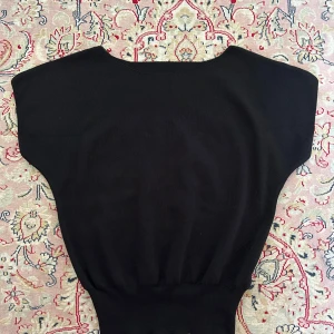 Svart topp - Taggen kvar. Stretch i midjan