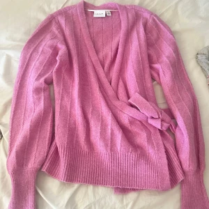 Stickad kofta - Säljer en jättefin v-neck wrap knit cardigan från Vila. Det är i storlek S i färgen rosa. Den är helt oanvänd pga att färgen inte matchade så bra på mig. Nypris: 515kr. Säljer den för 160kr. Skriv gärna innan vid intresse 💕💕