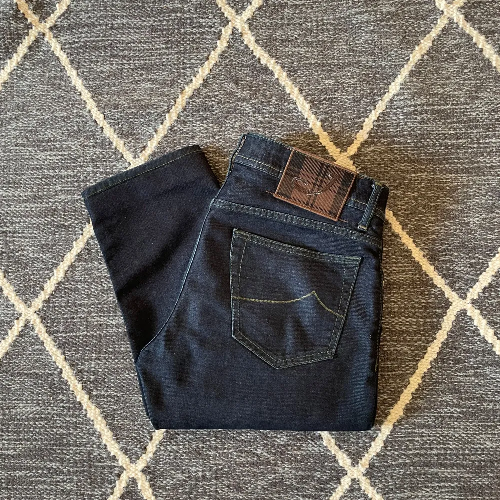 Säljer ett par snygga marinblå jeans.  Byxorna har en slim passform och är tillverkade i ett bekvämt bomullsmaterial. Perfekta för höst och vinter! Märke : Jacob Cohën. Style 622, storlek W34. Jeans & Byxor.