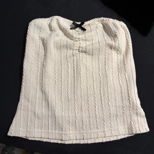 Vit topp - En fin vit strapless topp och väldigt bekväm, den är inte använd mycket ! 