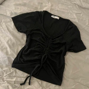 topp rosett stl xs  - Fin kort topp med knyte rosett fram. Från new yorker o i stl xs, fint skick !💗