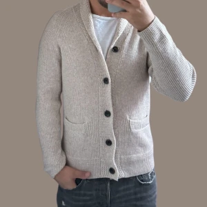 Beige stickad kofta med knappar - Säljer en snygg beige stickad kofta med stora knappar och två fickor fram. Perfekt för höst och vinter, den är både stilren och bekväm. Passar bra till både vardag och lite finare tillfällen. 🧥✨