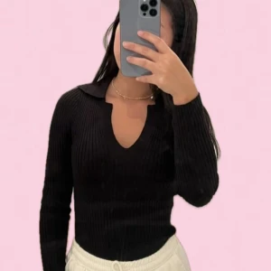 Svart ribbad tröja med krage - Säljer en stilren svart ribbad tröja med krage och v-ringning. Tröjan har långa ärmar och en tight passform som framhäver figuren. Storlek M men passar även S eller Xs också då den är väldigt stretchig.