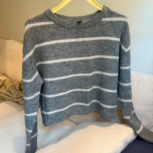 Grå randig tröja - Säljer en supermysig grå tröja från H&M Divided i storlek XS. Den är randig med vita ränder och har långa ärmar. Perfekt för höst och vinter! Tröjan är i bra skick!